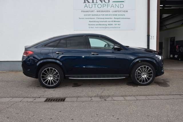 Side view of a sleek dark blue luxury SUV parked on a street.